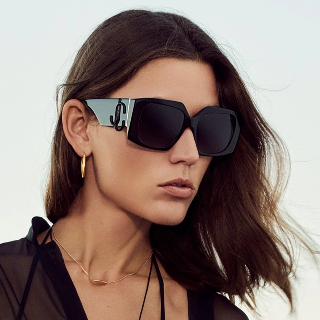 A woman showcasing glamorous Jimmy Choo sunglasses with shimmering details.
