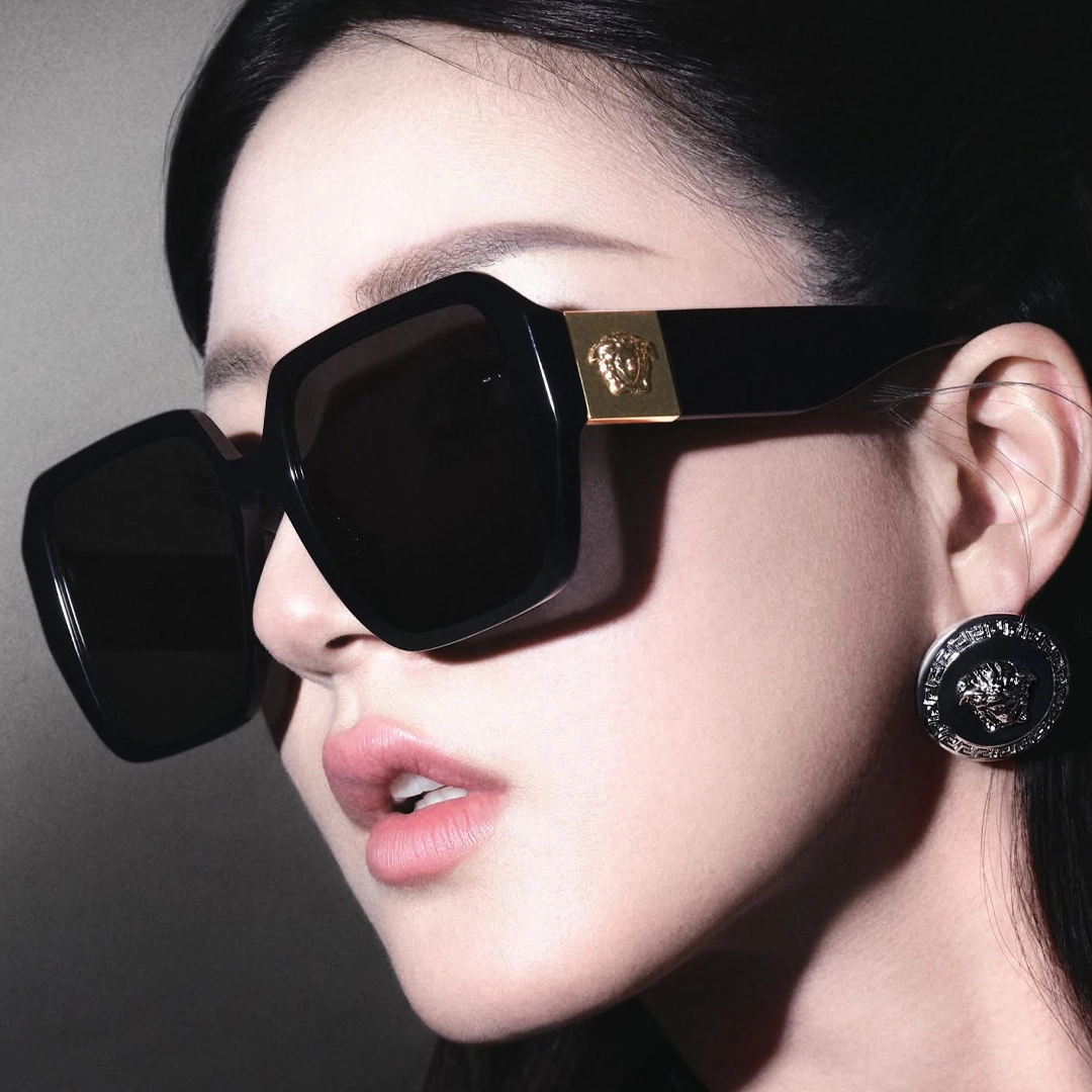 A model in glamorous and opulent Versace sunglasses featuring the Medusa emblem.